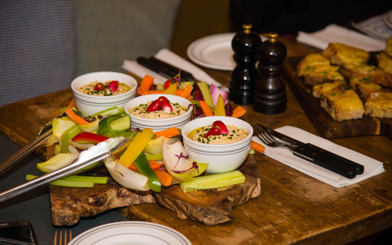 Elegant Italian catering spread with fresh pasta, aged meats, and artisan cheeses arranged on marble with warm lighting